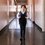 Editorial illustration of a student with a backpack walking through a school hallway.